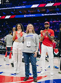 Sunny Jackson waves at the crowd from the court at a Philadelphia 76ers game.